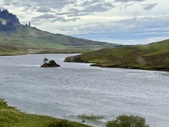 Scenic view of sea and mountains against sky