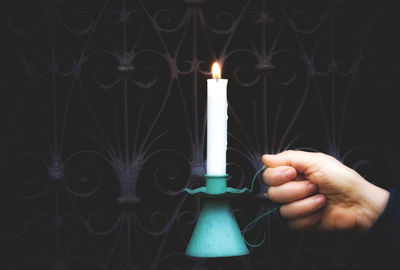 Close-up of hand holding candles