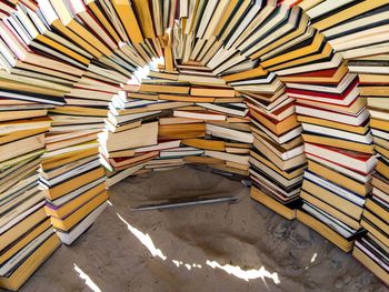 Books arranged in arch shaped on sand