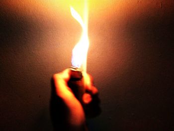 Close-up of hand holding lit candle