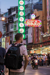 Rear view of man walking on street in city