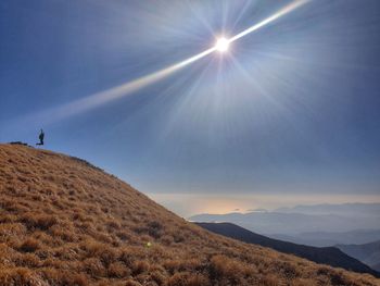 Scenic view of landscape against bright sun