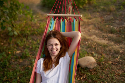 Portrait of smiling woman sitting in hammock