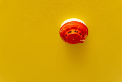 Close-up of electric lamp against yellow wall