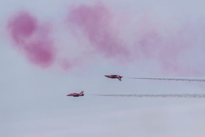 Low angle view of airshow against sky