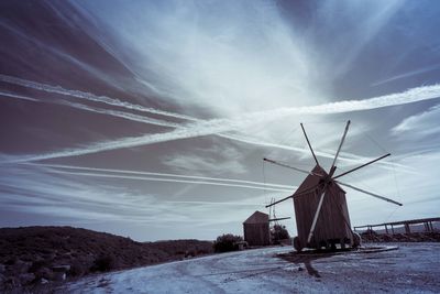 Traditional windmill on field against sky