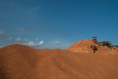 Sand dunes at mining site against sky