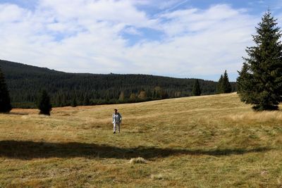 Man running on field against sky