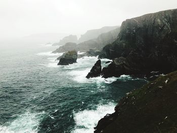 Scenic view of rocks in sea against sky