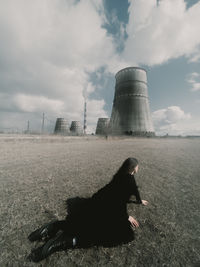 Rear view of woman standing on field against sky