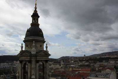 Buildings in city against cloudy sky