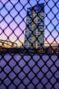 View of city seen through chainlink fence