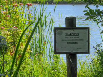 Close-up of information sign on grass