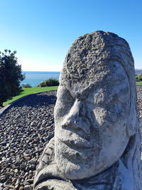 Close-up of rock on beach against clear blue sky