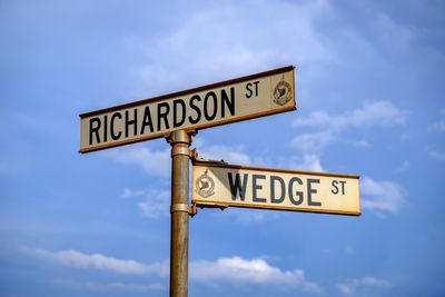 Low angle view of road sign against sky