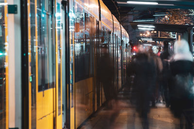 People standing by train at railroad station platform