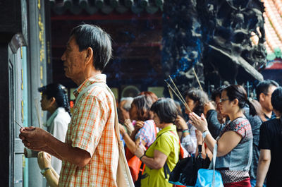 Rear view of people standing at temple
