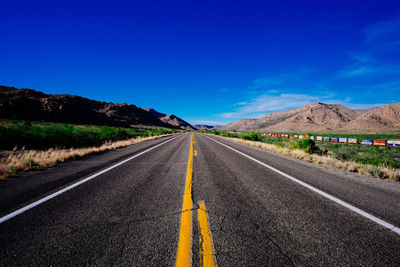 Empty road against blue sky