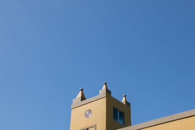 High section of building against clear blue sky