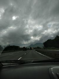 Road against sky seen through car windshield