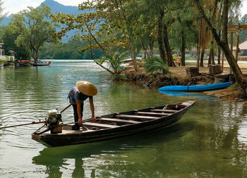 Man in boat on lake against trees