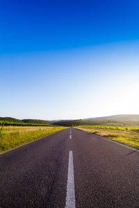 Empty road against blue sky