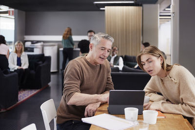 Two professionals working together in office cafeteria