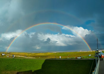 Scenic view of rainbow over land against sky