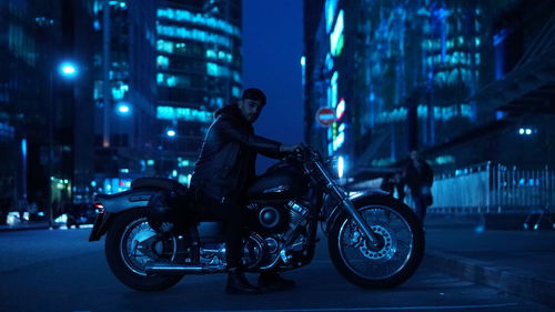 Man riding motorcycle on street at night