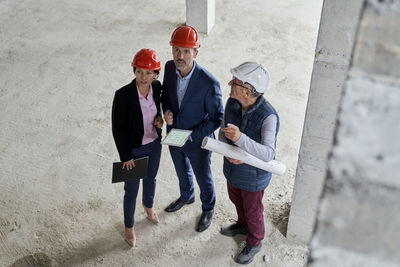 High angle view of engineers standing at construction site