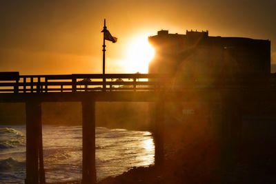 Pier on sea at sunset