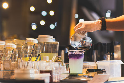 Man making butterfly tea with yuzu juice in a tak away glasses.