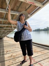 Full length of woman standing on pier over lake