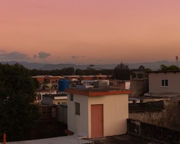 Buildings in town against sky during sunset