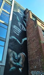 Low angle view of statue against building in city