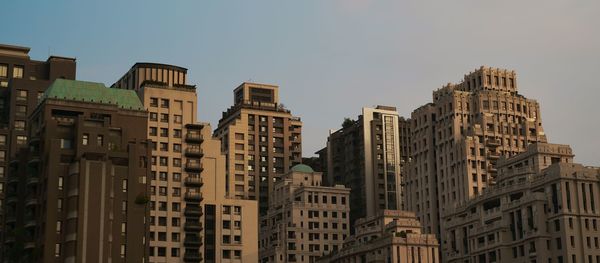 Buildings in city against clear sky