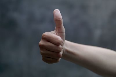 Cropped image of hand gesturing thumb up