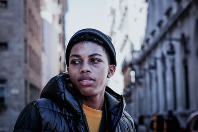 Young man looking away in city