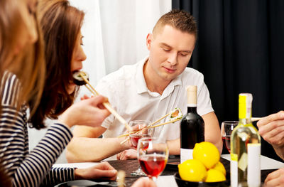 Young man and woman holding drink in glass