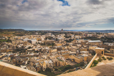 Cityscape against cloudy sky