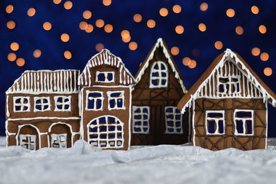 Gingerbread houses against illuminated lights at night