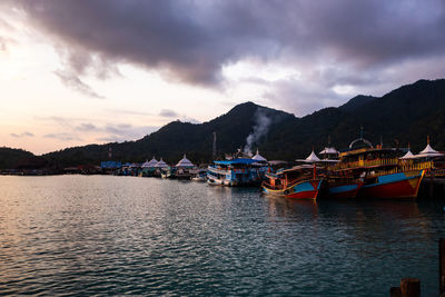 Sailboats moored in sea against sky