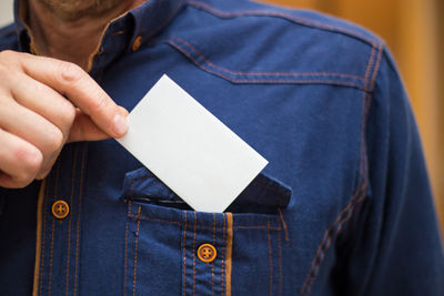 Midsection of person holding paper