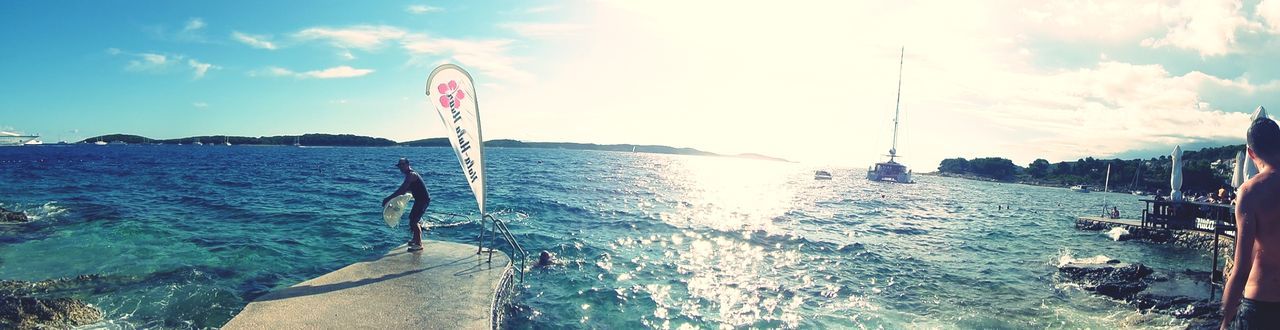 water, sea, sky, beach, leisure activity, cloud - sky, lifestyles, nautical vessel, shore, flag, sunlight, horizon over water, transportation, men, incidental people, vacations, day, nature, outdoors