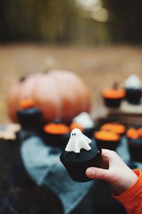 Cropped hand holding muffin during halloween