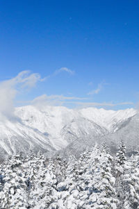 Scenic view of snowcapped mountains against blue sky