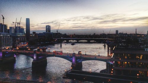 Bridge over river with cityscape in background