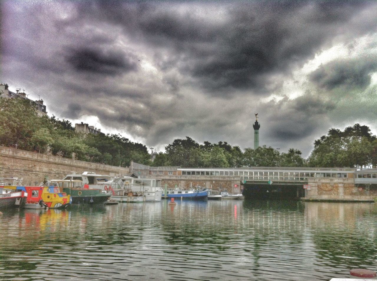 cloud - sky, water, sky, cloudy, transportation, waterfront, nautical vessel, mode of transport, built structure, river, architecture, weather, overcast, cloud, boat, lake, building exterior, nature, tranquility, tree