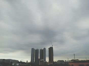 Low angle view of modern buildings against cloudy sky