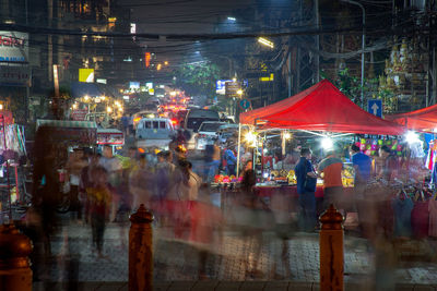 People on illuminated street market at night